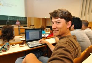 Student mit Laptop in einer Vorlesung